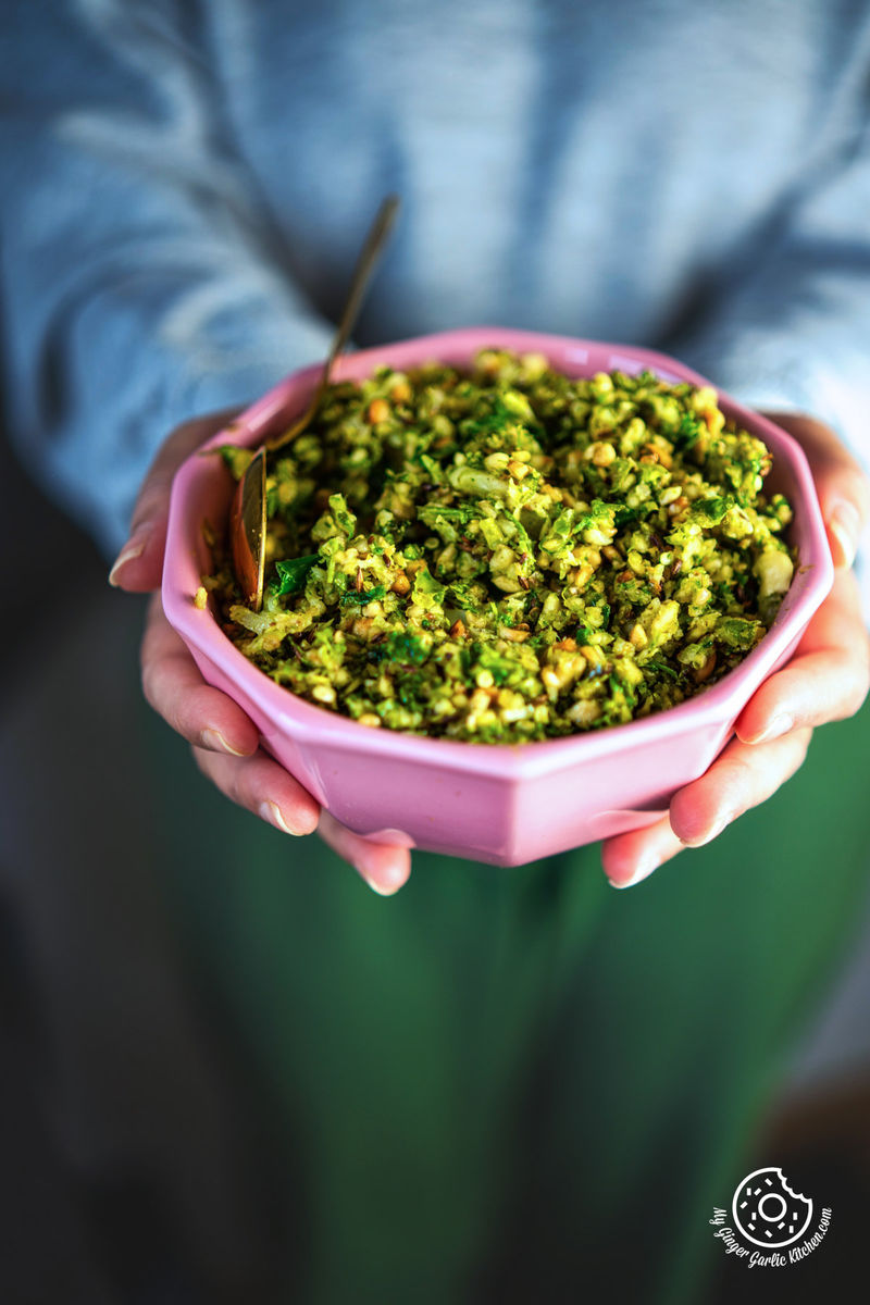 a close up of a female holding a pink bowl with mirchi ka thecha