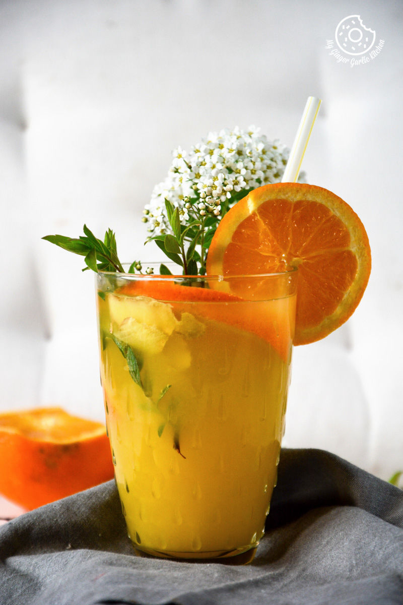 a glass of virgin ginger mimosa with a straw and a flower